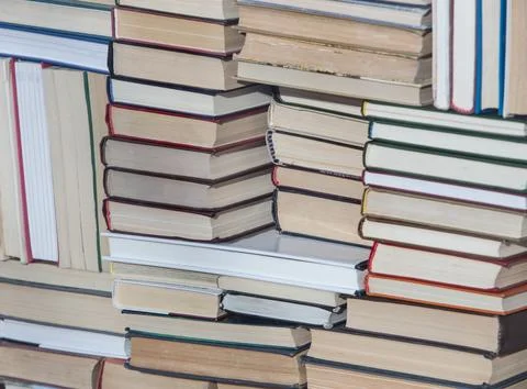 Stack of chaotically stacked books of different size and form. Close-up. Stock Photos
