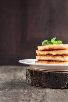 Stack of cheesecakes on a white plate and a dark wooden background Stock Photos