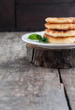 Stack of cheesecakes on a white plate and a dark wooden background Stock Photos