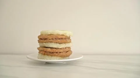 Stack of chicken and pork patties with bread slices on a white plate Stock-Fotos