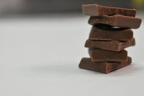 A stack of choclate bars packed as a gift on a black background and copy spac Stock Photos