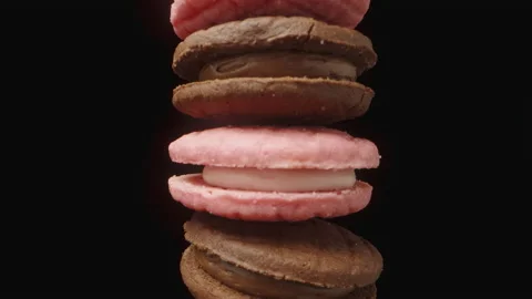 A stack of chocolate and pink cookies with cream between the halves, rotating Stock Footage 221917401