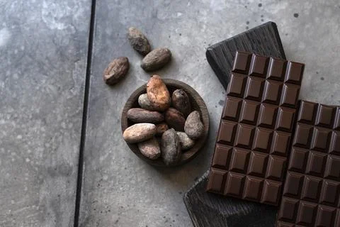 Stack of chocolate bars with cocoa beans. Flat lay composition with delicious Stock Photos