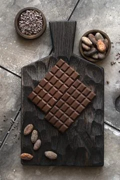 Stack of chocolate bars with cocoa beans. Flat lay composition with delicious Stock Photos