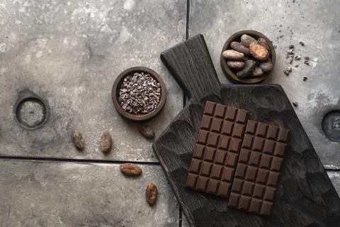 Stack of chocolate bars with cocoa beans. Flat lay composition with delicious Foto stock
