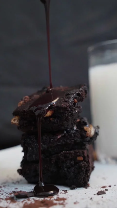 A stack of chocolate brownie made with nuts pouring with melted chocolate syrup. Stock Footage 283362033