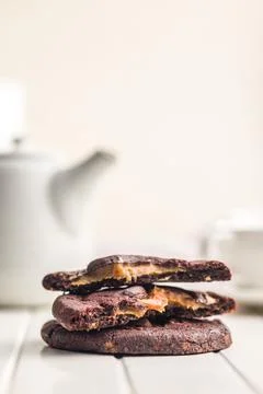 Stack Of Chocolate Caramel Cookies Close-Up On White Table With Coffee Cup .. 스톡 사진