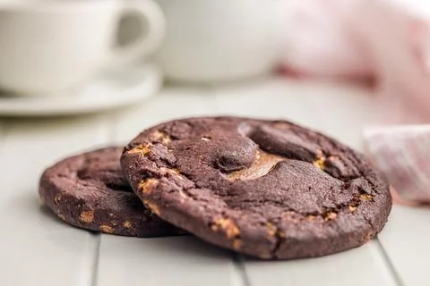 Stack Of Chocolate Caramel Cookies Close-Up On White Table With Coffee Cup .. 스톡 사진