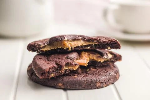 Stack Of Chocolate Caramel Cookies Close-Up On White Table With Coffee Cup .. 스톡 사진