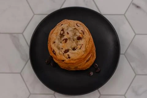 Stack of chocolate chip cookies on black plate in kitchen 스톡 사진