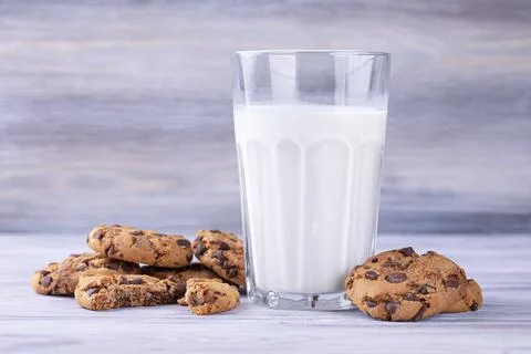 A stack of chocolate chip cookies lies near a glass of milk. Calcium-rich mil Stock-Fotos