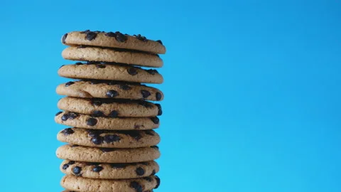 A stack chocolate chip cookies rotate on a blue background. Stock Footage 157477100
