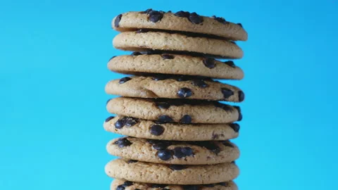 A stack chocolate chip cookies rotate on a blue background. American cookies Stock Footage 157500712