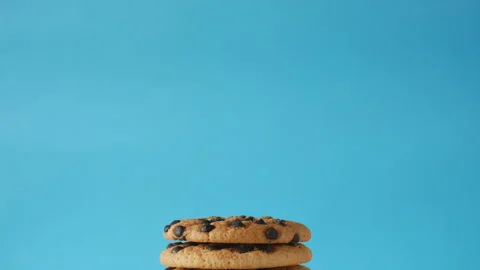 A stack of chocolate chip cookies sprout on a blue background. American cookies Stock Footage 156858925