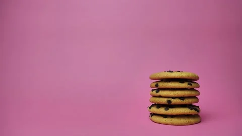 A stack of chocolate chip cookies sprouting on a pink background. American Stock Footage 180677352