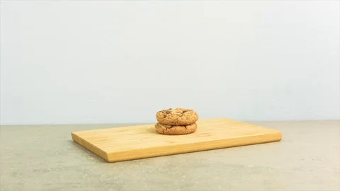 Stack of chocolate chip cookies on a wooden cutter. Stop motion film clip. Stock Footage 69828018