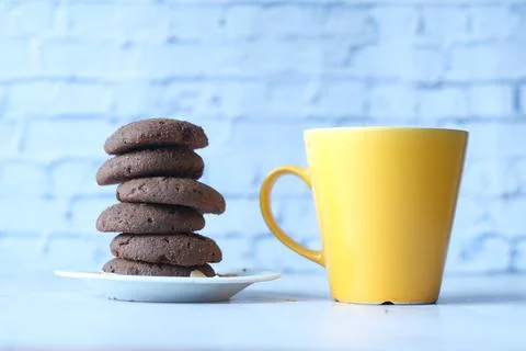 Stack of chocolate cookies and coffee mug on table Foto stock
