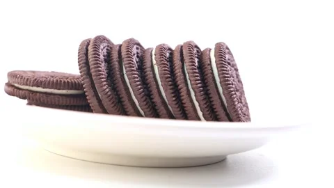 Stack of chocolate cookies with cream filling slowly rotating on white plat.. Stock Footage 332408008