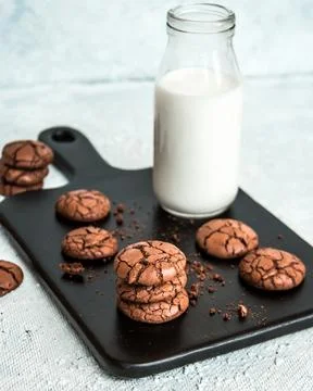Stack of Chocolate Cookies with Milk on a Black Serving Board 스톡 사진