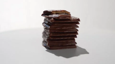 Stack of chocolate-covered crackers rotating with a bite taken from the top Stock Footage 344992906