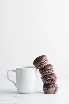 The stack of chocolate muffins with a white mug Stock Photos