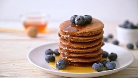 Stack of chocolate pancakes with blueberries and syrup Stock Photos