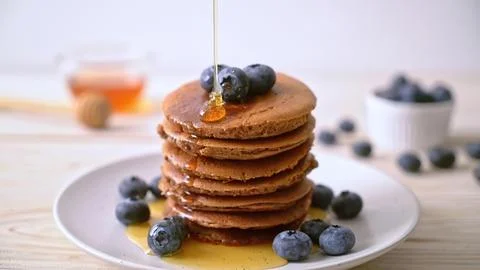 Stack of chocolate pancakes with blueberries and syrup Stock Photos