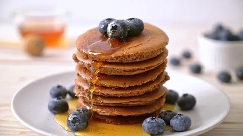 Stack of chocolate pancakes with blueberries and syrup Stock Photos