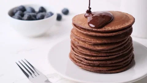Stack of chocolate pancakes pouring over chocolate sauce. Stock Footage 169443940