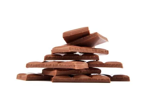 Stack of chocolate pieces on a white background. Stock Photos