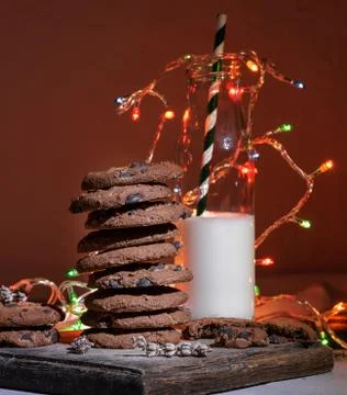Stack of chocolate round biscuits, a glass bottle with milk Stock Photos