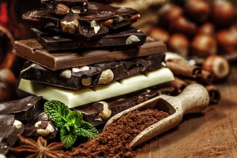 Stack of chocolate slices with mint leaf on a wooden table.Assortment of fine Stock Photos