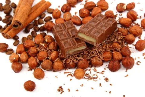 Stack of chocolate tiles with hazelnuts and cinnamon sticks. Stock Photos