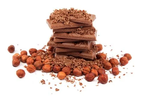 Stack of chocolate tiles with hazelnuts on a white background. Stock Photos
