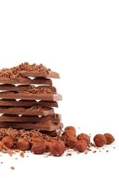 Stack of chocolate tiles with hazelnuts on a white background. Stock Photos