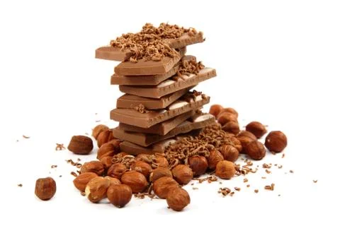 Stack of chocolate tiles with hazelnuts on a white background. Stock Photos