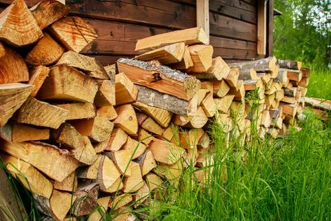 Stack of chopped firewood. Eco-friendly bio fuel. Woodpile near village house Stock Photos