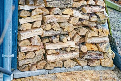 Stack of chopped firewood logs neatly arranged outdoors for winter fuel use Stock Photos
