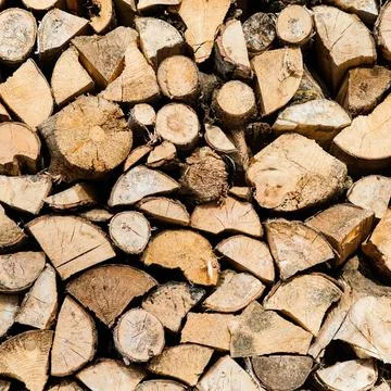 Stack of chopped firewood logs in a pile for fire Stock Photos