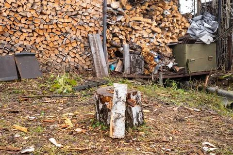 Stack of chopped firewood with a tree stump and split log in front. Rural 스톡 사진