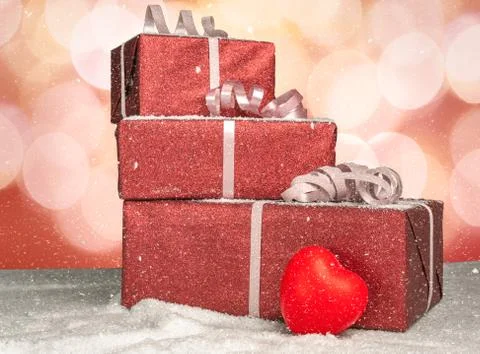 Stack of christmas presents with a heart on a table with snow Stock Photos