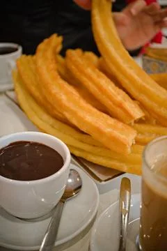 A stack of churros with cups of hot chocolate. Stock Photos