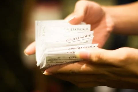 Stack of Cinema Tickets Held by Hands Photos