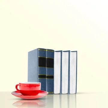 Stack of classic blue books standing upright next to a vibrant red coffee c.. Stock Photos
