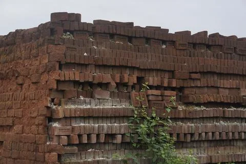 Stack of clay bricks arranged neatly at a construction site, Stockfoto's