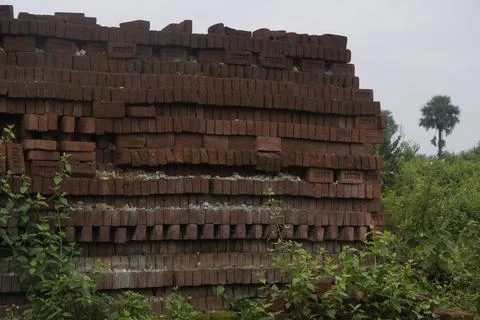 Stack of clay bricks arranged neatly at a construction site, Stock Photos