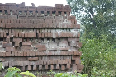 Stack of clay bricks arranged neatly at a construction site, Fotos Stock