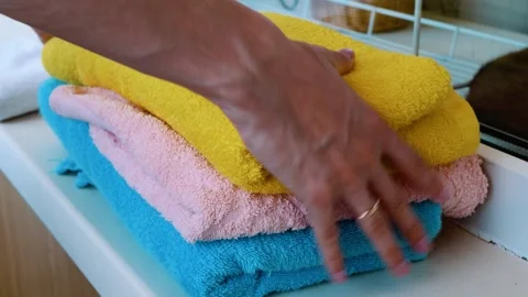A stack of clean colorful towels. Hands touching fabric Stock Footage 258837644