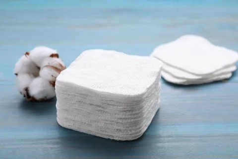 Stack of clean cotton pads on light blue wooden table, closeup Stockfoto's