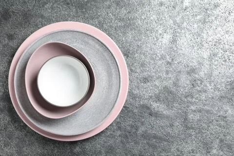 Stack of clean dishes on grey table, top view. Space for text 写真素材
